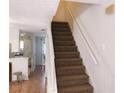 Carpeted staircase featuring white handrails and access to the upper level at 6658 Ramsgate Way, Norcross, GA 30093
