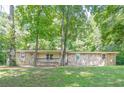 Single-story stone home with a covered front porch, nestled among tall trees and a grassy lawn at 109 Amberidge Nw Dr, Cartersville, GA 30121