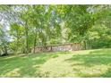 Single-story home with stone facade, covered front porch and spacious grassy front yard with mature trees at 109 Amberidge Nw Dr, Cartersville, GA 30121