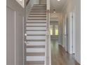 Inviting entryway featuring hardwood floors, a staircase with neutral walls and trim at 636 Leafy Branch Way, Mcdonough, GA 30253