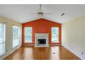Bright living room featuring hardwood floors, a white fireplace, and vaulted ceilings at 9550 Canvasback Ct, Jonesboro, GA 30238