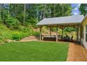 Well-designed backyard patio features a covered area with ample seating and a lush green lawn at 2277 Lazy Days Rd, Dacula, GA 30019