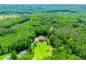 Aerial view of a secluded home surrounded by lush trees and greenery in a private and serene setting at 6919 Mount Zion Rd, Waco, GA 30182
