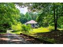 Charming home nestled in a lush, wooded setting with a well-manicured lawn and inviting, tree-lined driveway at 6919 Mount Zion Rd, Waco, GA 30182