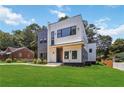 Beautiful new construction home with unique gray and white exterior, landscaped lawn, and modern design at 1554 Columbia Cir, Decatur, GA 30032