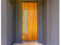 Stylish front door featuring a wood finish and a vertical glass insert, set in a modern gray frame at 1554 Columbia Cir, Decatur, GA 30032