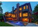 Exterior view of the back of a brick home with a pool, spa, screened-in porch, and lush landscaping at 1984 Mendenhall Cir, Atlanta, GA 30341