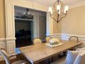 Elegant dining room with chandelier, wainscoting, and view into the living room at 1984 Mendenhall Cir, Atlanta, GA 30341