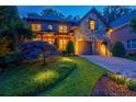Exterior view of a two-story brick home with a stone facade and a well-manicured lawn, lit up at night at 1984 Mendenhall Cir, Atlanta, GA 30341