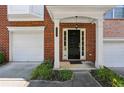Close-up of the front door and covered porch on a brick townhome at 5126 Wellsley Bnd, Alpharetta, GA 30005