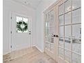 Bright foyer with hardwood floors, glass paneled office doors and the front door with decorative window wreath at 306 Coppergate Ct, Holly Springs, GA 30115