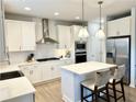 Well-lit kitchen showcasing stainless steel appliances, a center island with seating, and sleek white cabinetry at 306 Coppergate Ct, Holly Springs, GA 30115