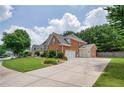 Spacious driveway leading to a three-car garage, surrounded by lush greenery and well-maintained landscaping at 5635 Upper Creek Ct, Suwanee, GA 30024