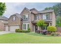 Charming two-story brick home featuring manicured lawn and landscape and a three car garage at 470 Wagon Hill Ln, Sugar Hill, GA 30518