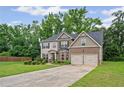 Traditional two-story home featuring an attached two-car garage and a well-maintained lawn at 397 Victory Ln Ln, Locust Grove, GA 30248