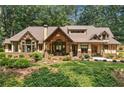 Attractive view of home with a covered porch, large windows, mature landscaping, and a well-maintained lawn at 2149 Batesville Rd, Canton, GA 30115