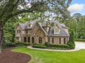 Spacious brick home featuring beautiful landscaping, mature trees, and a welcoming front facade at 4304 Berkford Ne Cir, Brookhaven, GA 30319