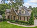 Well-maintained brick home with lush landscaping, mature trees, and a circular driveway at 4304 Berkford Ne Cir, Brookhaven, GA 30319