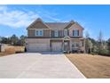 Charming two-story home with a three-car garage and lovely curb appeal on a sunny day at 157 Donovan Ave, Locust Grove, GA 30248
