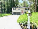 Charming split-level home with a two-car garage, freshly painted exterior, and well-manicured front lawn at 6965 Kimberland Gardens Ln, Lithonia, GA 30058