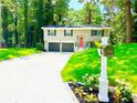 Inviting home exterior with well-manicured lawn, landscaped flower beds, and a classic mailbox at 6965 Kimberland Gardens Ln, Lithonia, GA 30058