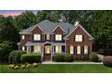 Charming two-story brick home with a well-manicured lawn and mature landscaping at 2145 Sugarstone Ct, Lawrenceville, GA 30043