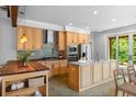 Bright kitchen features wooden cabinets, stainless appliances, island with seating, and access to the outdoor patio at 407 Westside Dr, Roswell, GA 30075