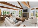 Open-concept living room boasts a cozy fireplace, exposed beams, and seamless access to the kitchen and outdoor views at 407 Westside Dr, Roswell, GA 30075