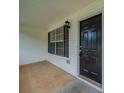 Front porch area featuring a black front door, light fixture, and white siding with dark shutters at 40 Heather Woods Ct, Covington, GA 30016