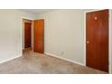 Simple bedroom showing two interior doors, neutral walls, carpet, and functional space, ideal for customization at 6126 Knights Ln, Douglasville, GA 30135
