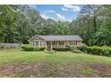 Inviting single-story house with a well-maintained lawn surrounded by trees at 1904 Britt Dr, Snellville, GA 30078