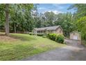 Single-story home with a lush yard and a detached garage and driveway at 1904 Britt Dr, Snellville, GA 30078