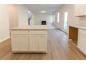 Bright kitchen featuring white cabinets and granite countertops that opens to a living room with a fireplace at 324 Bloomfield Cir, Canton, GA 30114