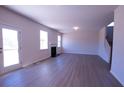 An open-concept living room features a fireplace, wood-grain vinyl floors, and lots of light from the door and windows at 324 Bloomfield Cir, Canton, GA 30114