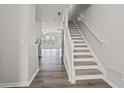 Bright entryway with hardwood floors, stairs with white railing, and an open view into the living area at 1510 Paramount Ln, Sugar Hill, GA 30518