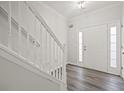 Inviting entryway with hardwood floors, stairs with white railing, and a bright white front door at 1510 Paramount Ln, Sugar Hill, GA 30518