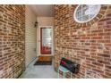 Close-up of entryway with red door and brick exterior with round window at 3221 Abbott Dr # 5, Powder Springs, GA 30127