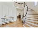 Bright foyer featuring wood floors, curved staircase with black trim, and light walls at 5602 Asheforde Ln, Marietta, GA 30068