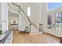 Bright foyer with wood floors, black-trimmed staircase, stained glass front doors and light walls at 5602 Asheforde Ln, Marietta, GA 30068