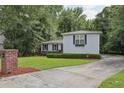 View of light gray house, green lawn, and long driveway at 1487 W Bend Creek Ct, Atlanta, GA 30338