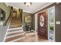 Elegant foyer with hardwood floors, staircase, and decorative front door at 1487 W Bend Creek Ct, Atlanta, GA 30338