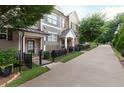 Inviting townhome exterior with well-maintained landscaping, black fence, and walkway at 318 Lantana Ln, Woodstock, GA 30188