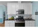 Modern kitchen featuring white cabinets, stainless steel appliances, and sleek black countertops at 859 Scales Rd, Suwanee, GA 30024