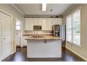 Well-lit kitchen with island, granite countertops, stainless steel appliances, and wood flooring at 2230 Laurel Lake Dr, Suwanee, GA 30024