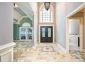 Spacious foyer with tiled floor, soaring ceilings, and beautiful chandelier and front door at 6065 Standard View Dr, Duluth, GA 30097
