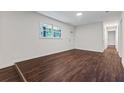 Spacious living room featuring dark wood flooring, fresh paint, a large window, and a modern doorway at 2091 Chestnut Log Dr, Lithia Springs, GA 30122