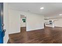 Open-concept living room with newly installed dark wood flooring, recessed lights and a view to the kitchen at 2091 Chestnut Log Dr, Lithia Springs, GA 30122
