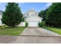 View of the back of the house with a spacious two-car garage and driveway at 1995 Liberty Hts, Fairburn, GA 30213