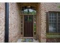 Elegant entryway with a dark wood door, brick surround, and classic lighting at 7185 Hartsfield Pl, Suwanee, GA 30024