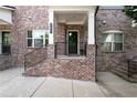 Welcoming brick porch with black iron railings leads to the front door of this charming townhome at 209 Snapdragon St, Woodstock, GA 30188